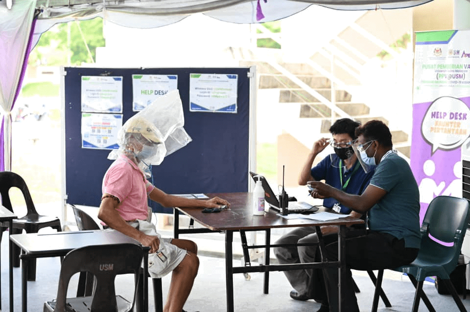 Uncle with absurd face shield generously treats frontliners to lunch after his jab