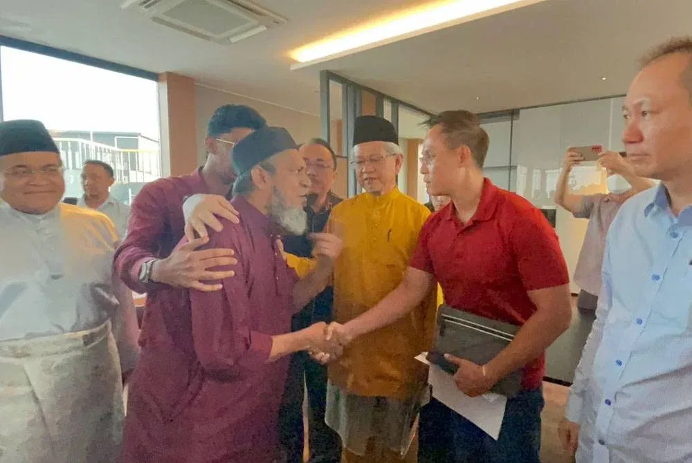 Try Pinnacle manager Alex Low shaking hand with Surau Saidina Umar manager, Muhammad Nasir.