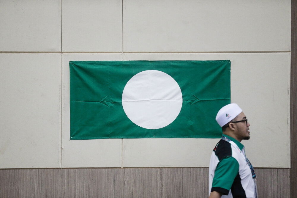 PAS supporter walking past party flag