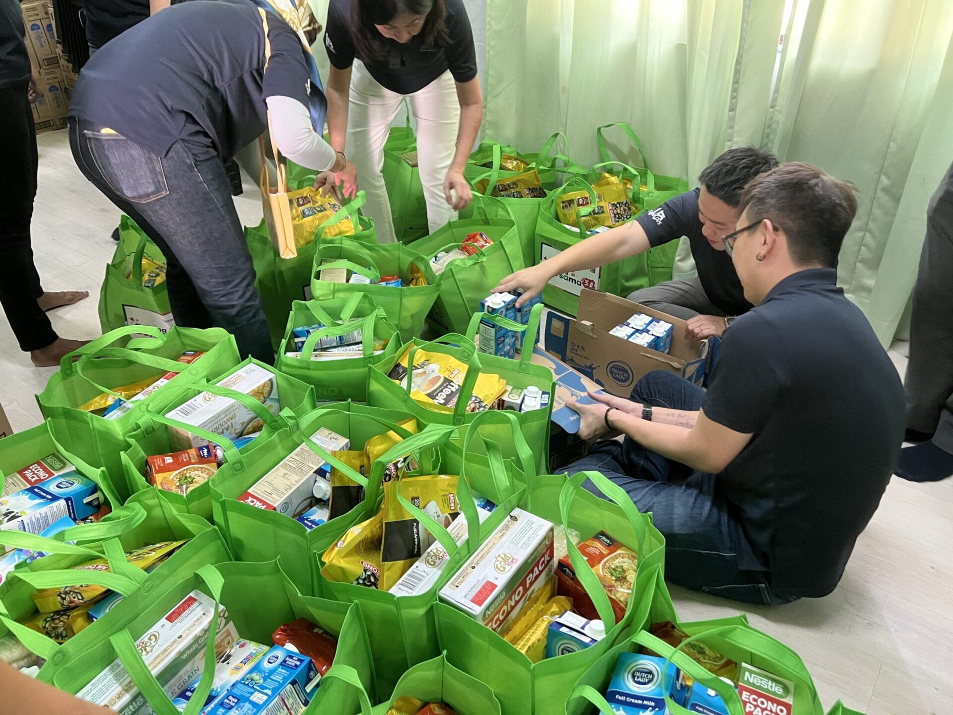 CapitaLand staff volunteers moving and packing donation items 1
