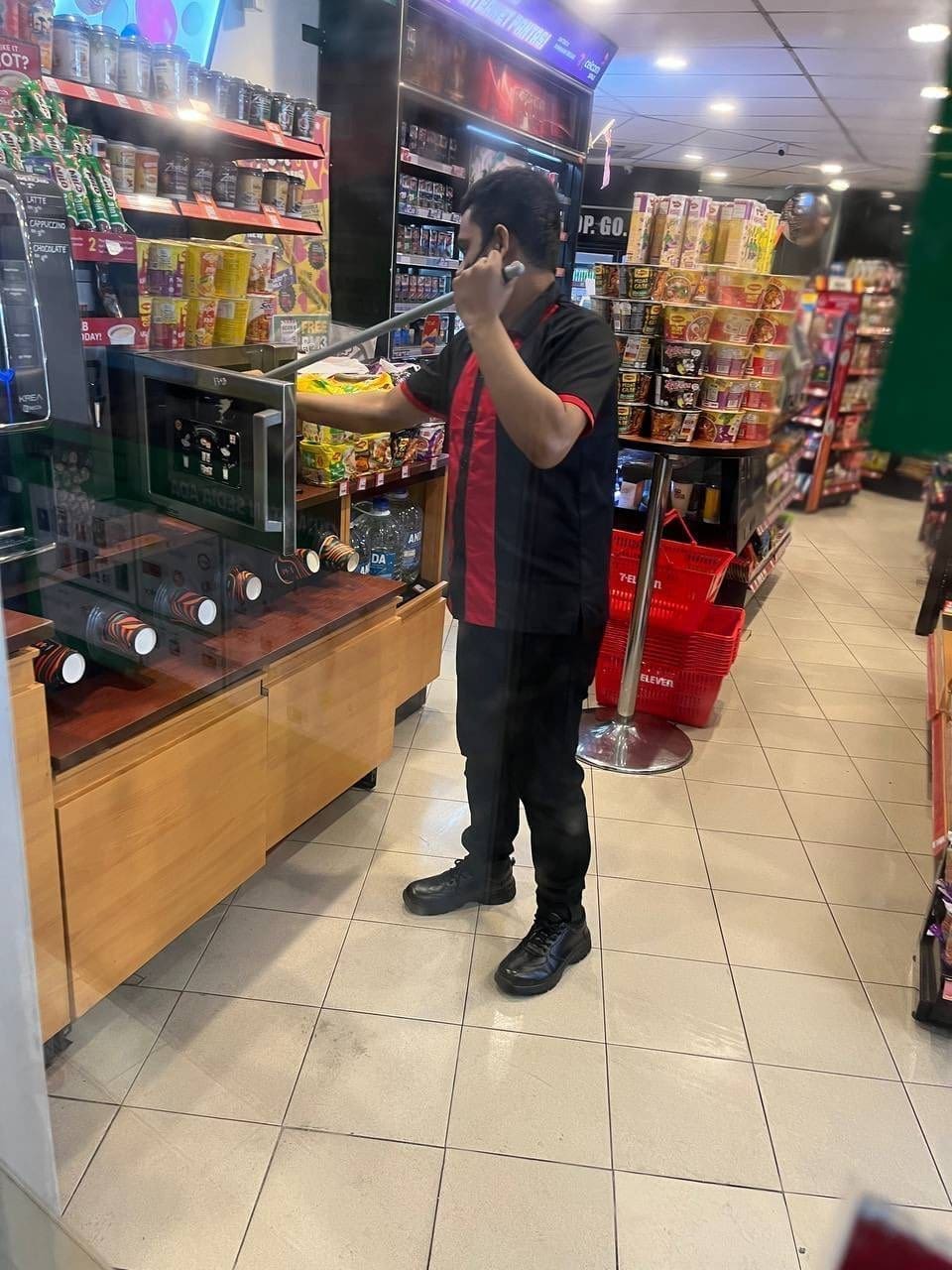 7-Eleven staff cleans microwave with mop