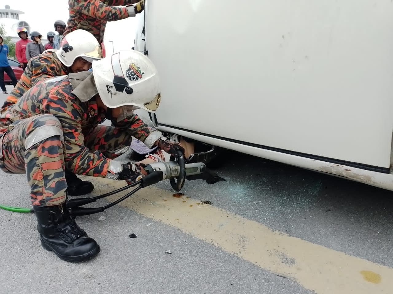 Firefighters using hydraulic cutters to extricate Ng Yoke Lin's body