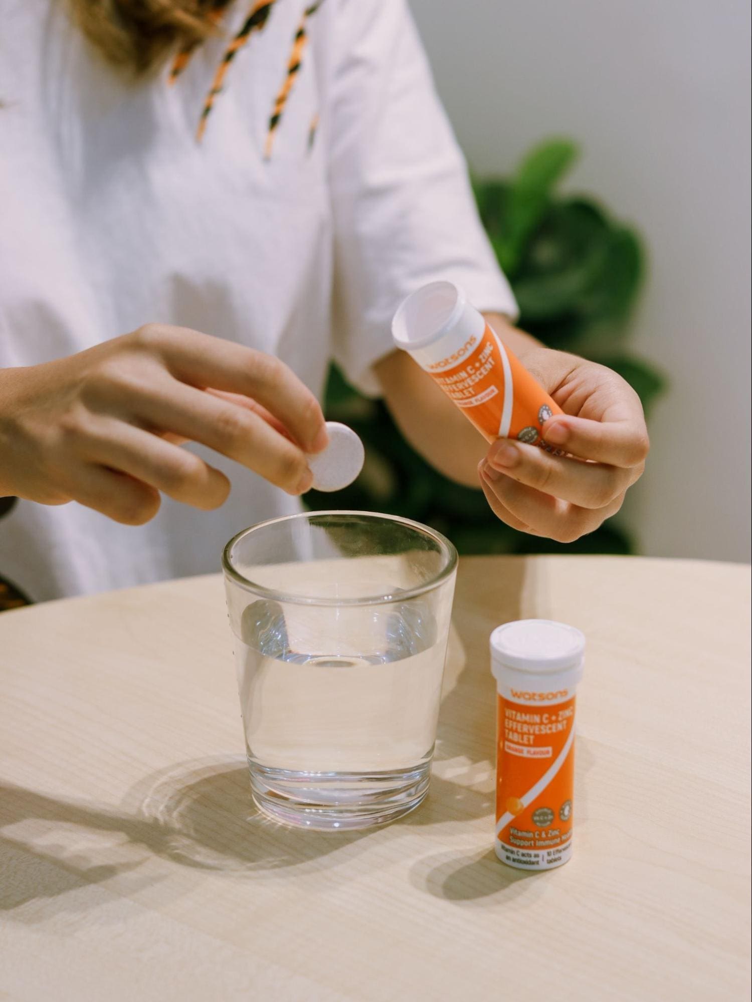 Asian woman consuming vitamins from Watsons