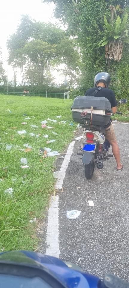 motorcyclist at littered spot in Singapore