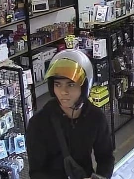 Man in helmet who runs off with 2 iPhones after pretending to do comparison