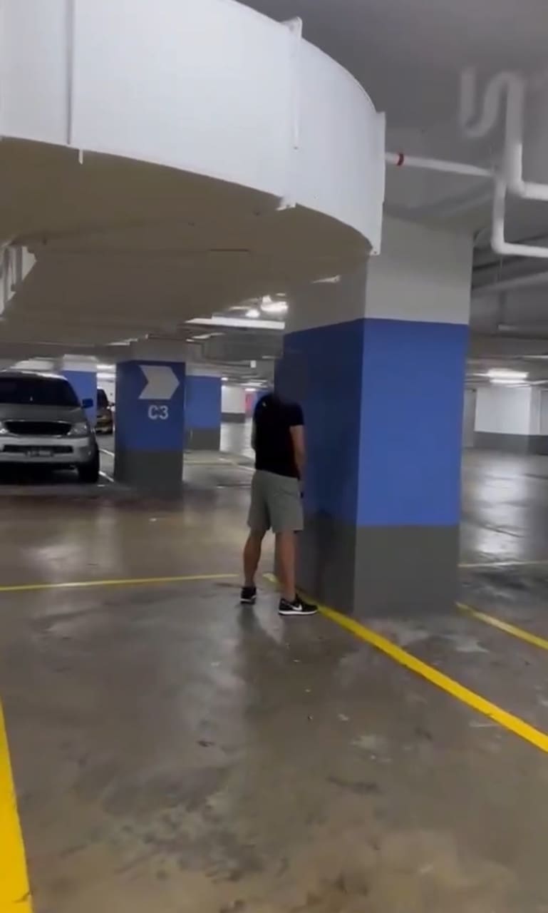 man peeing on the wall of a mall