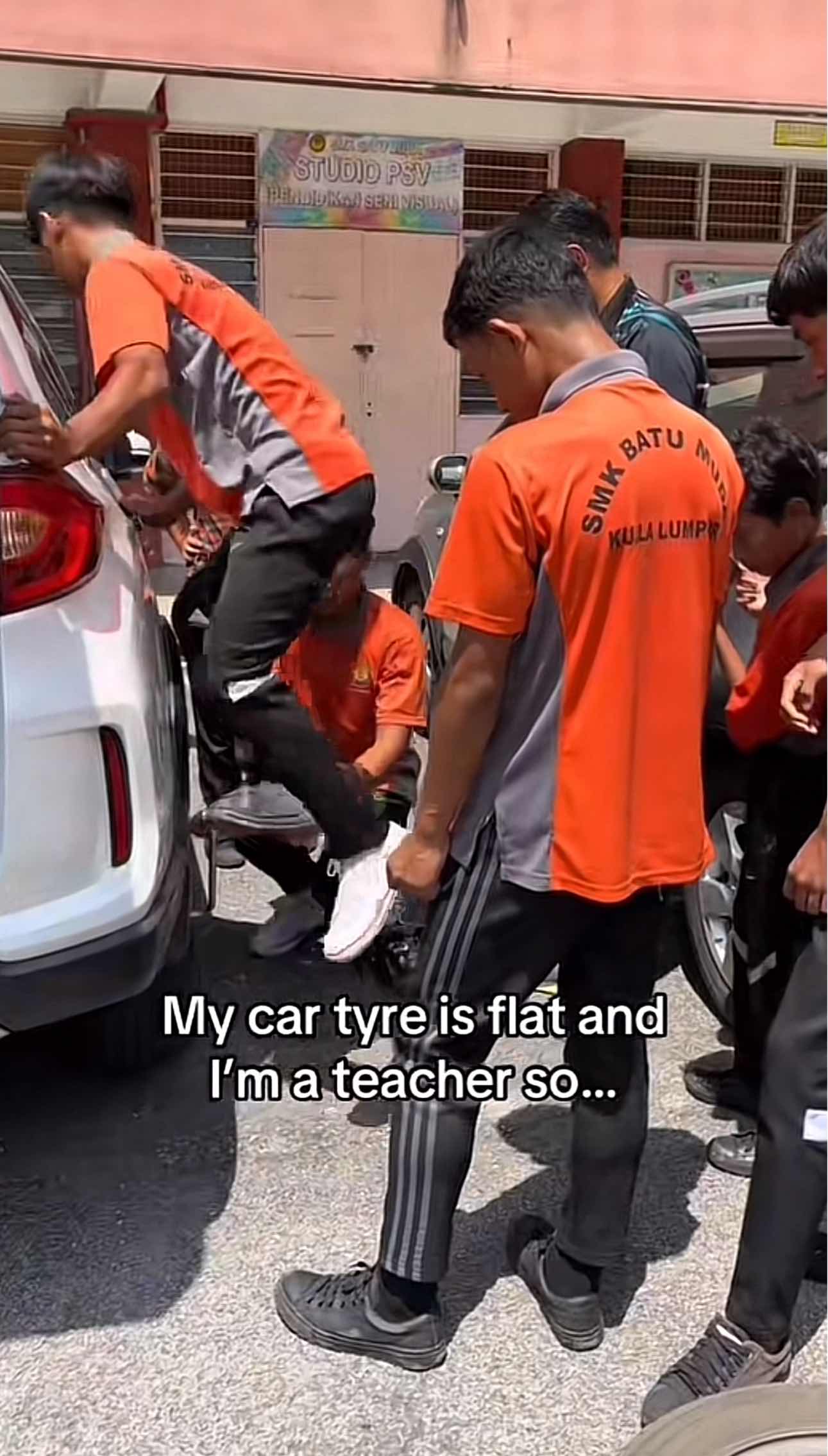 Students together fixing teacher's car