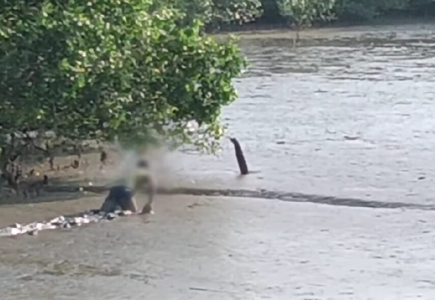 man crawling in mud water at penang