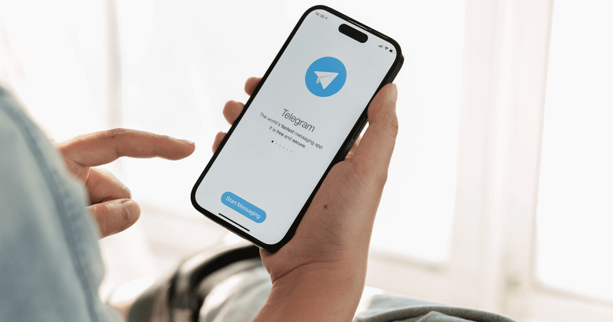 man is looking at telegram on his phone