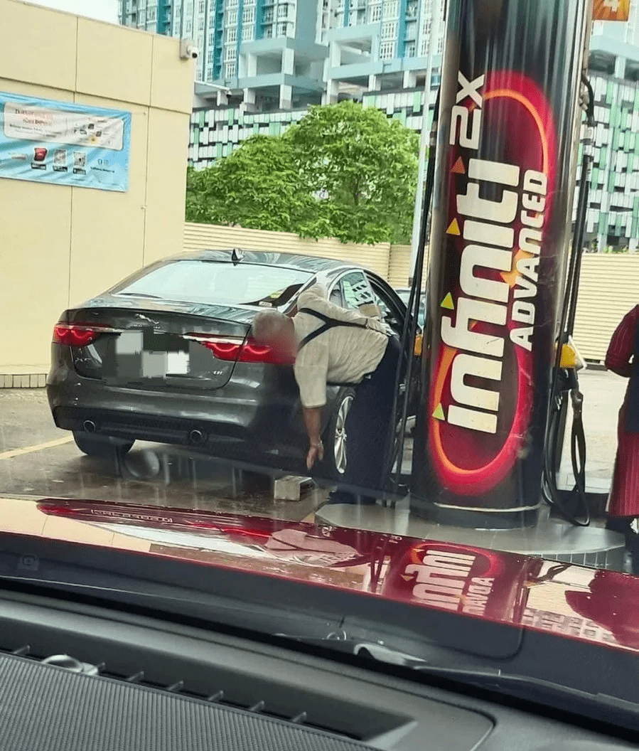 SG man puts brick underneath Jaguar