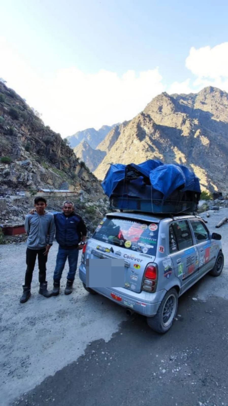 NURSULHI and Aidil standing near their car