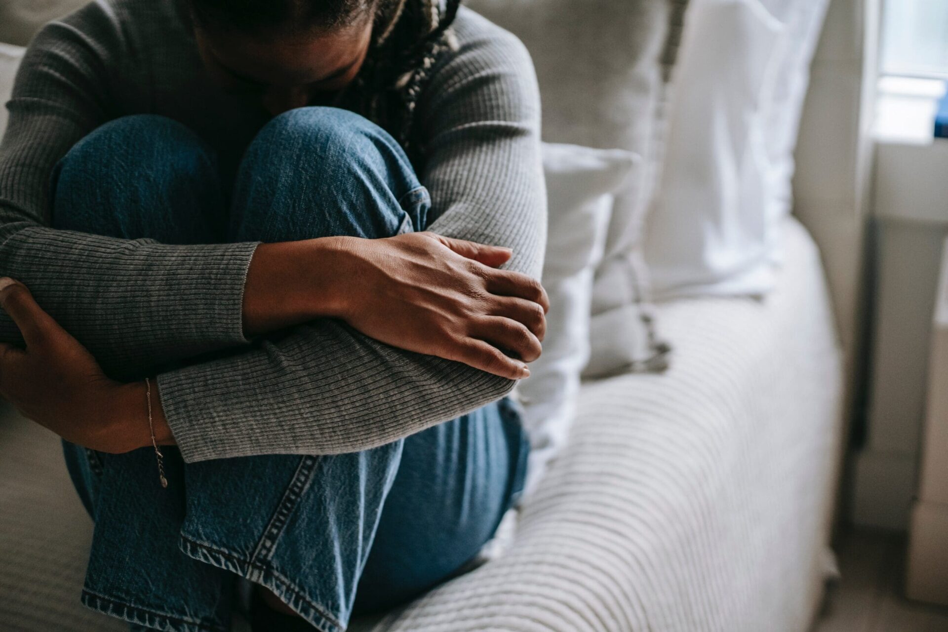 woman covering her face with her knees