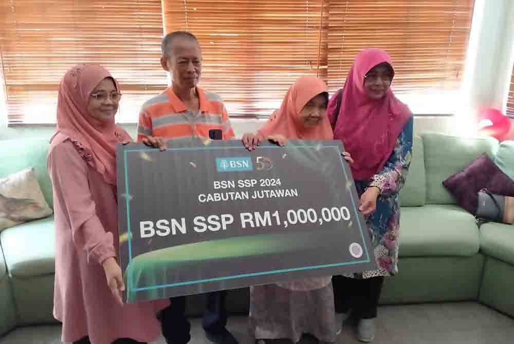 Mohd Nazri Abd Wazir poses with RM1mil mock cheque with family