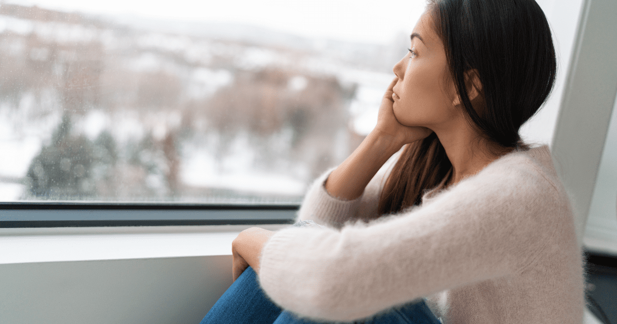 sad woman looking at that window