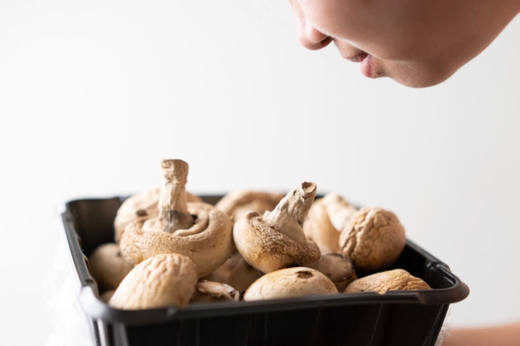 person smelling mushrooms