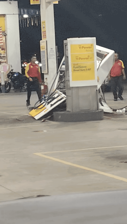 Staff walking towards damaged fuel pump in Johor