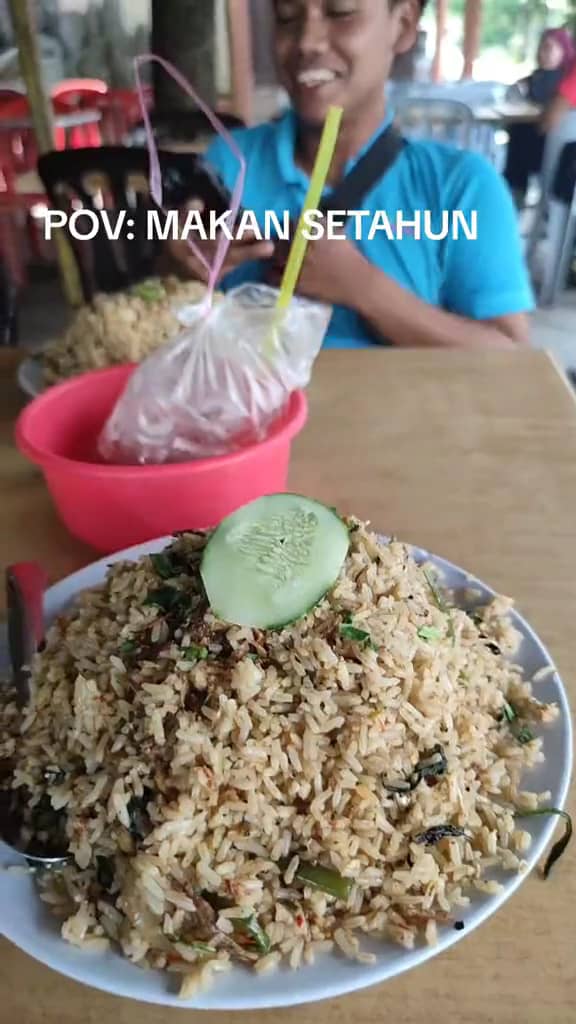 A M'sian shows the portion of fried rice that he received after ordering at a stall.