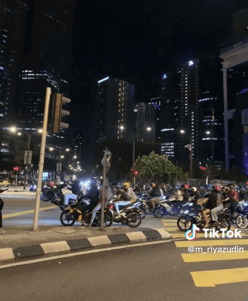 'Mat Rempit' does a wheelie at a traffic light near KLCC