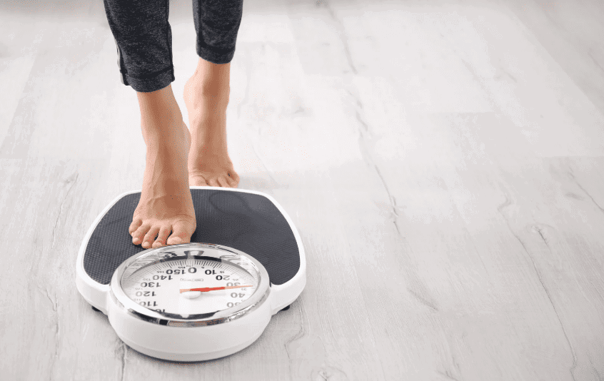 Woman using weighing scale