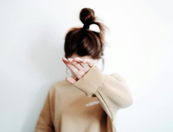 young girl hiding her face