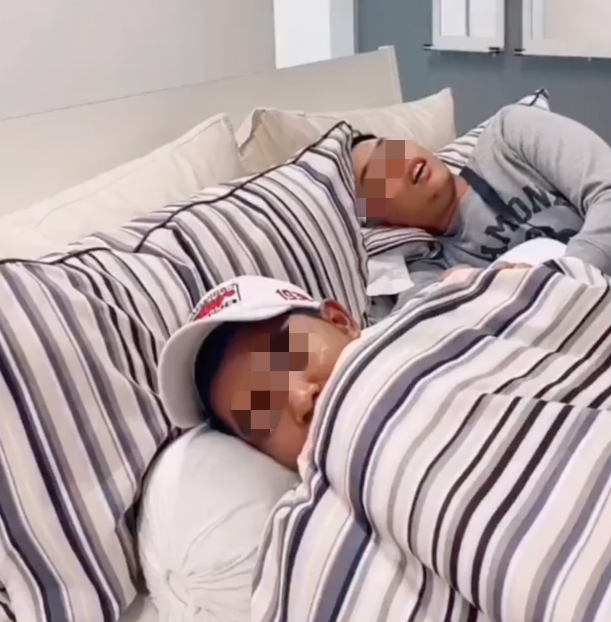 2 maskless men sleeping on a bed in ikea penang