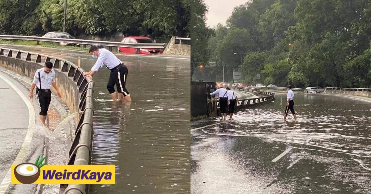 Traffic police get down and dirty to unclog drain along the nilai highway | weirdkaya