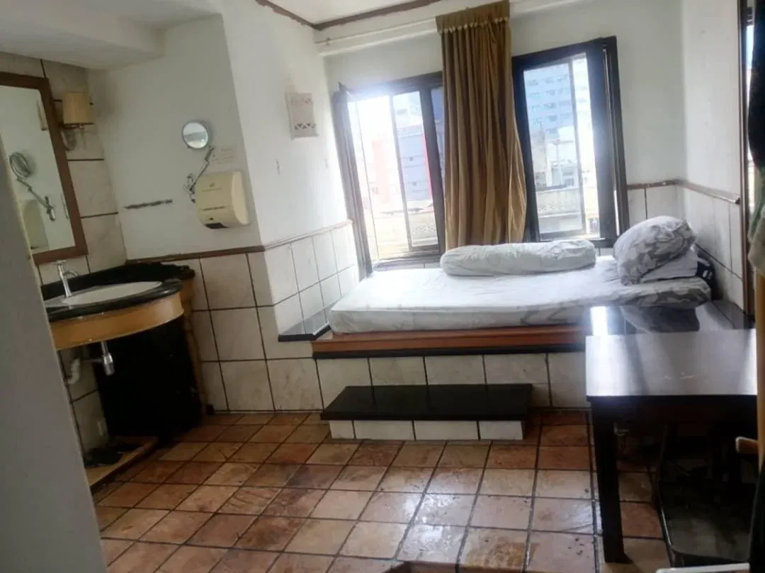 wk in the photo, a mattress could be seen placed inside a tiled room, with bathroom like features such as a sink, mirror and what appeared to be a bathtub like fixture underneath it.
