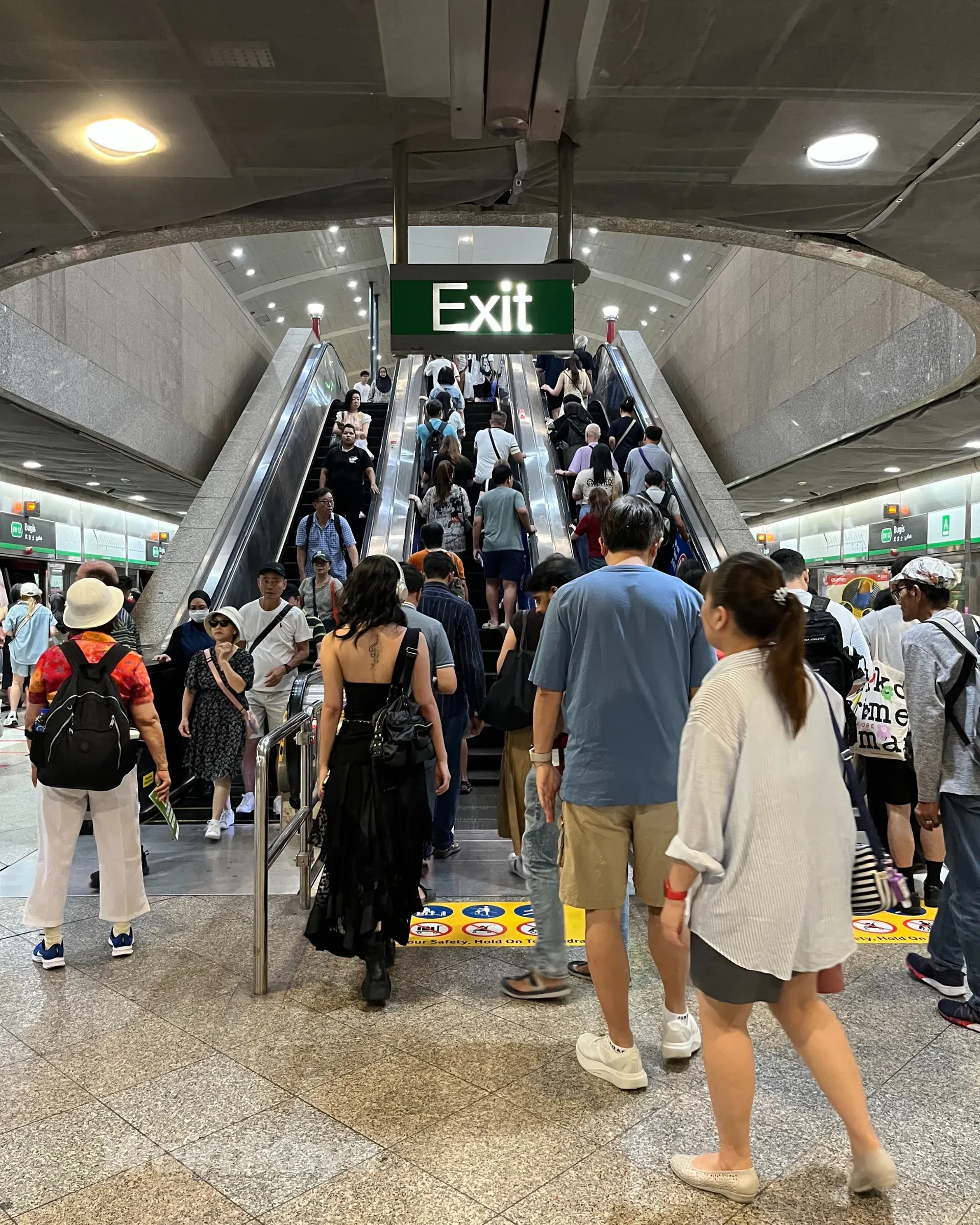 wk passengers taking escalator at bugis mrt station