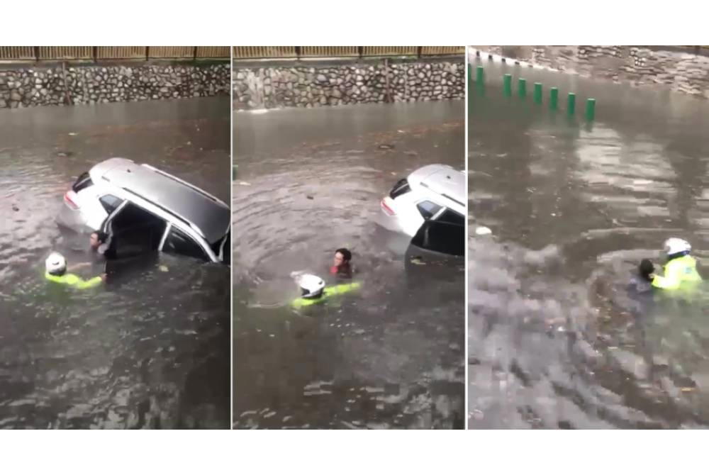 Malaysian traffic police risk his life to rescue driver trapped in flash flood