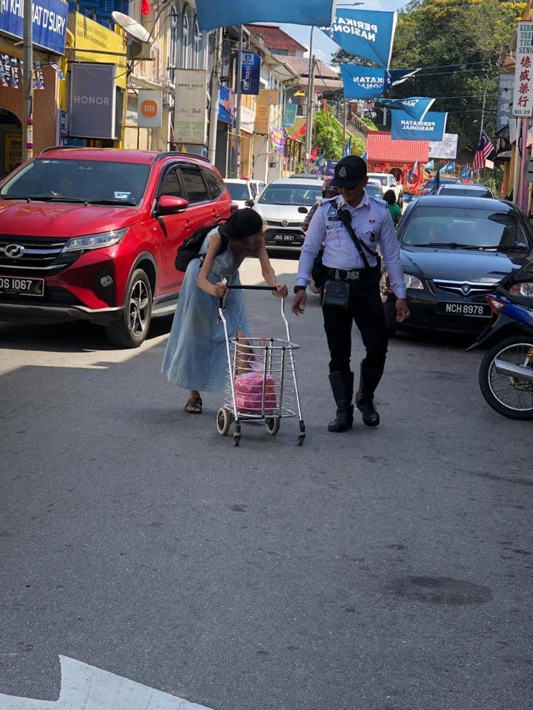 M'sian police officer praised for stopping traffic and helping woman cross the road