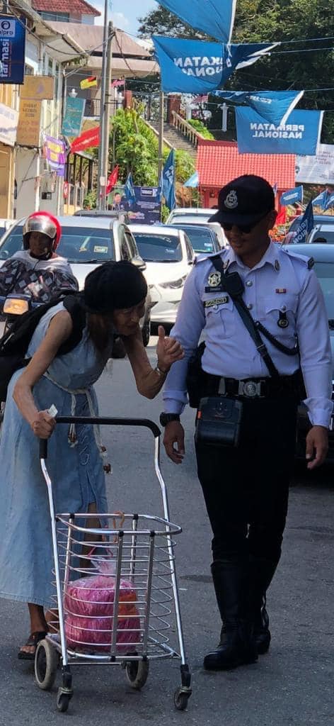 M'sian police officer praised for stopping traffic and helping woman cross the road