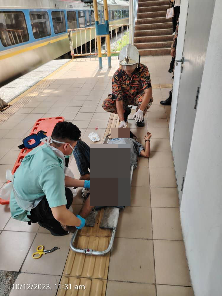 Medical staff checking teh condiiton of the woman on the stretcher who jumped on the lrt train track.