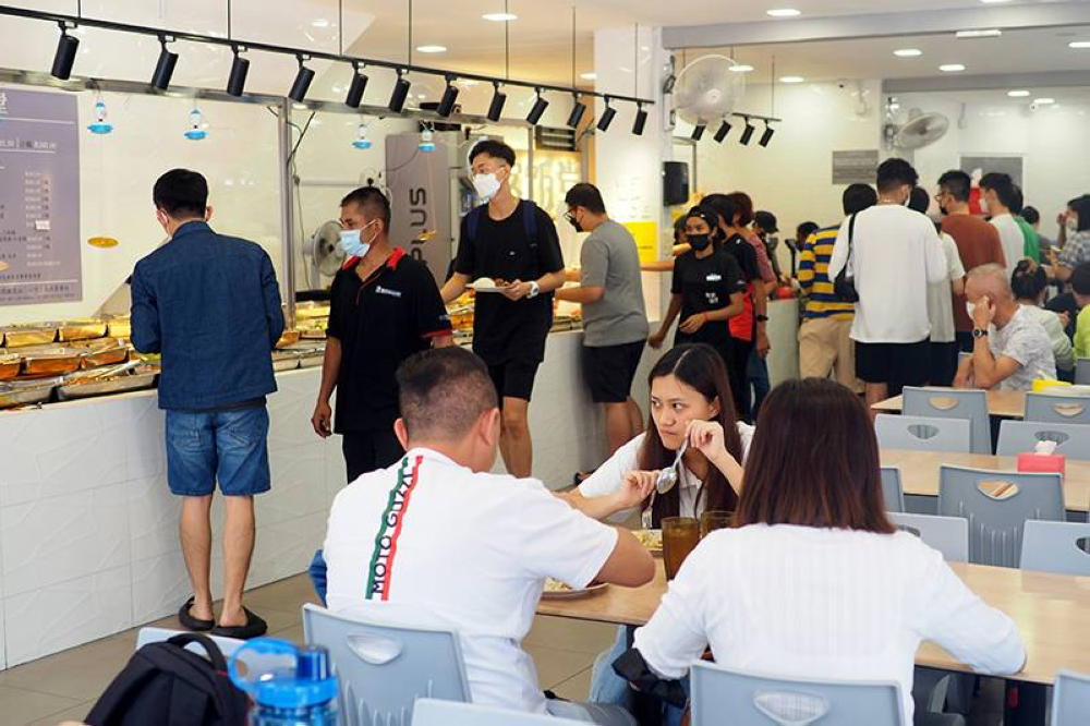 People eating and lining up at economy rice stall/restaurant