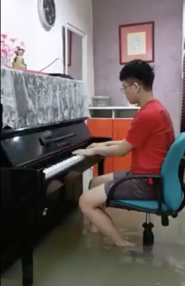 Mans play piano despite flooding in his house 01