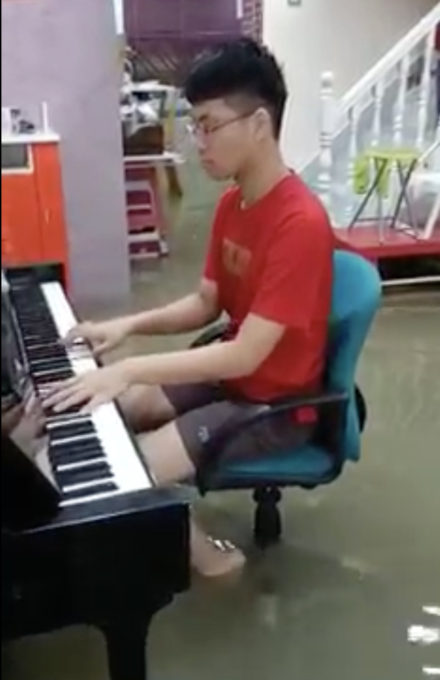 Mans play piano despite flooding in his house 02