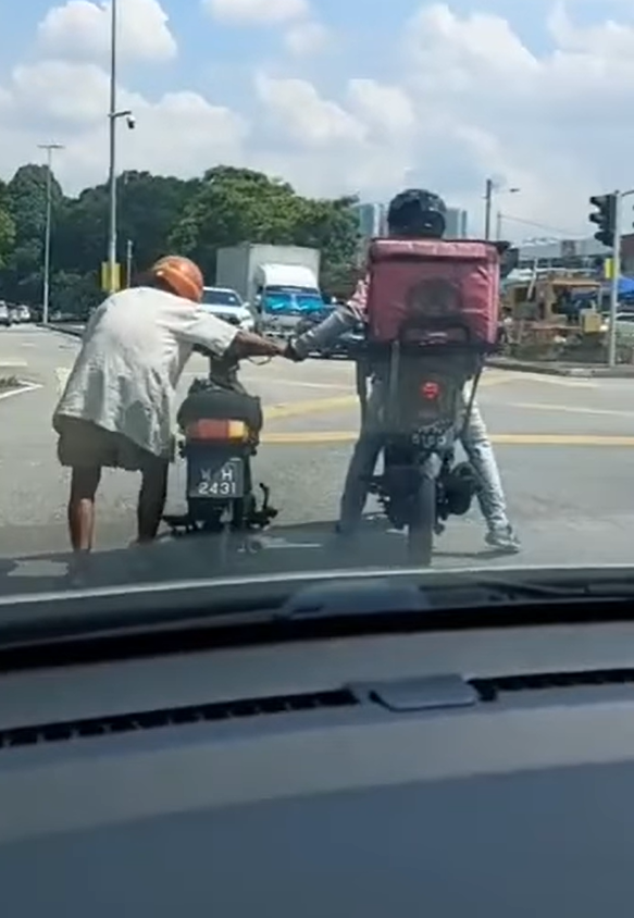 Kindhearted foodpanda rider helps elderly man push his motorbike under the hot sun