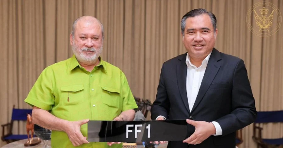 Sultan ibrahim holding his 'ff1' vehicle number plate that he own through a bid of rm1. 2 million.