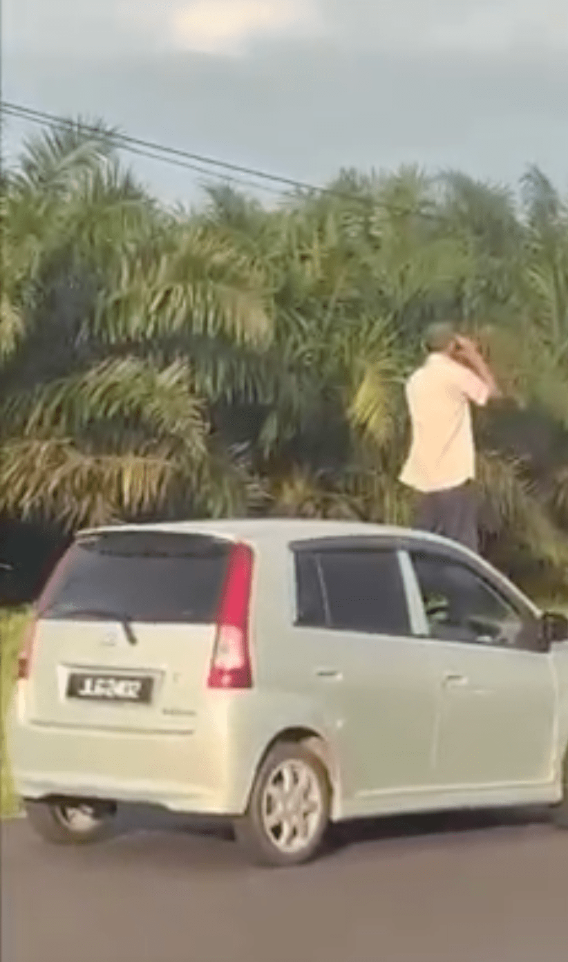 Uncle stuck in heavy raya traffic climbs onto car bonnet and checks the road with binoculars 01-min
