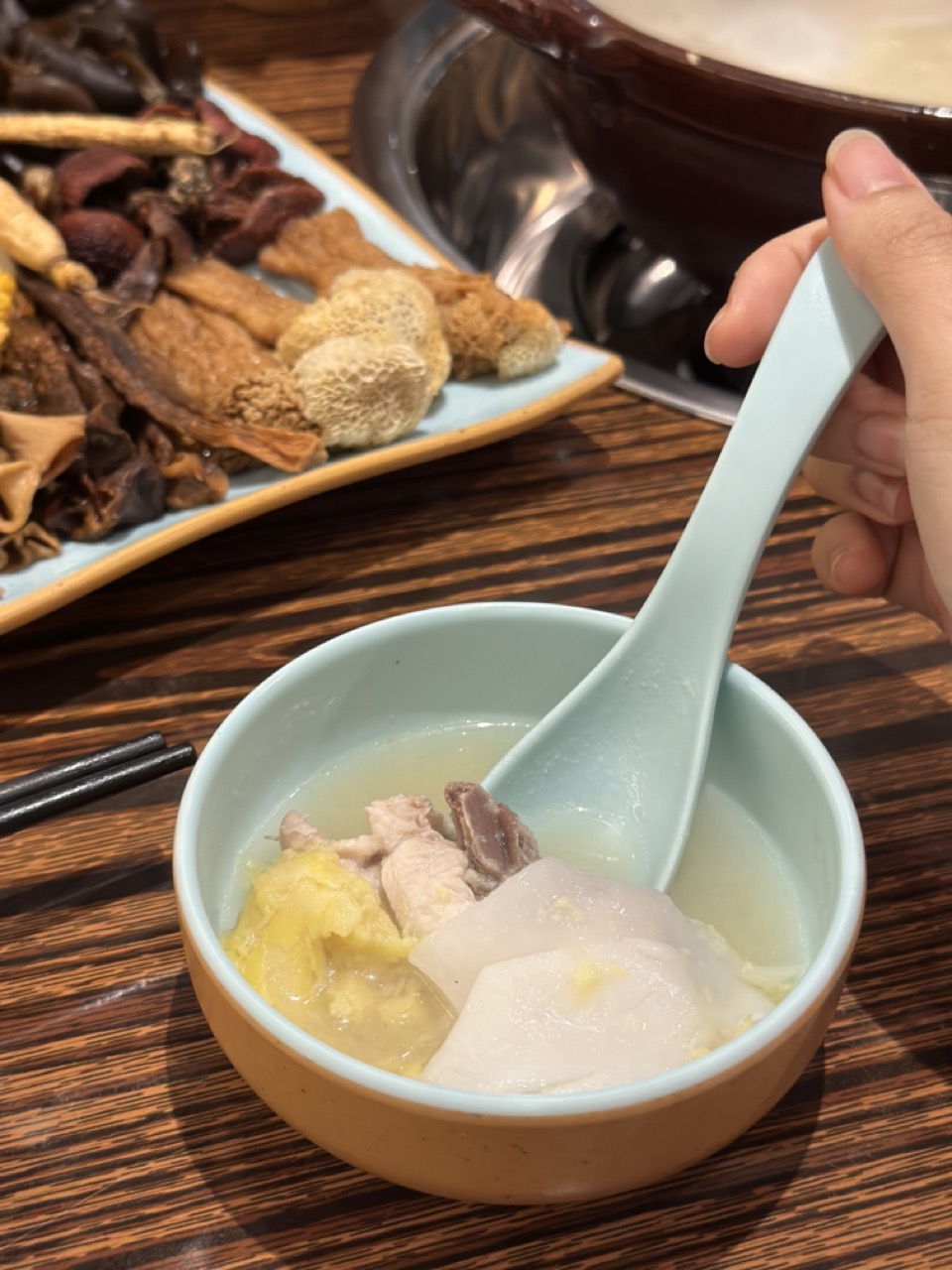 A bowl of soup with coconut, durian and chicken