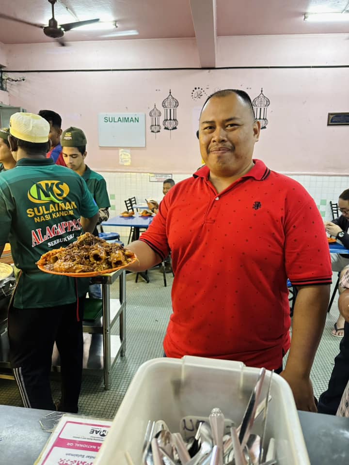 A customer holding his rm69 worth of nasi kandar meal.