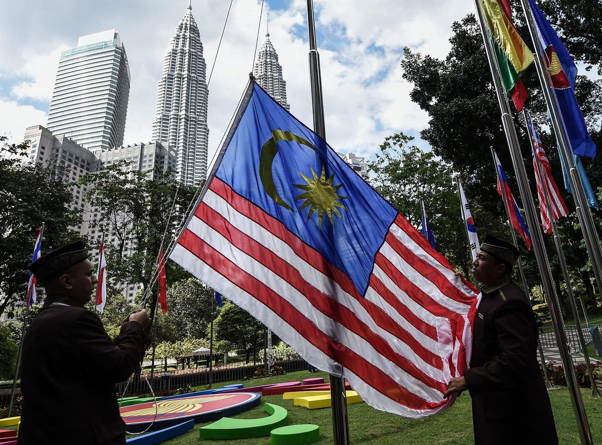 Officers hoisting the jalur gemilang