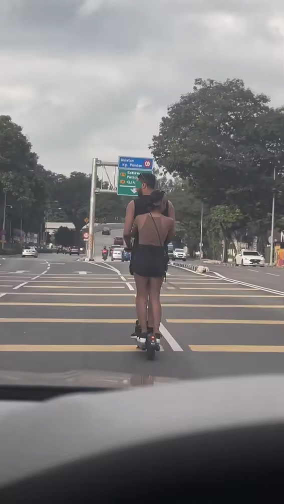 Angmoh man rides along road with a scooter