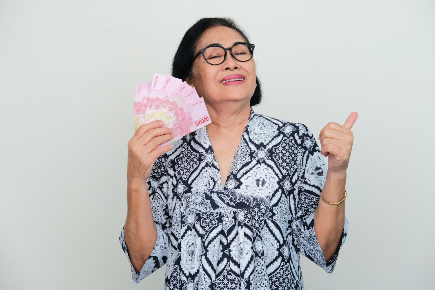 Asian-elderly-women-showing-happy-expression-give-thumb-up-when-holding-money