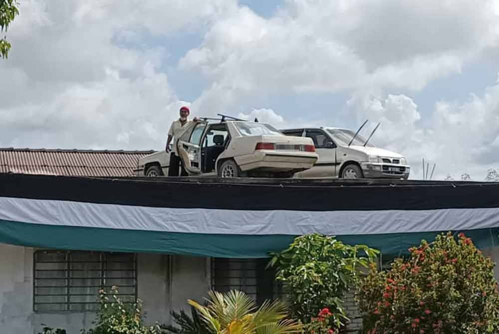 Awang ali with the cars parked on house roof