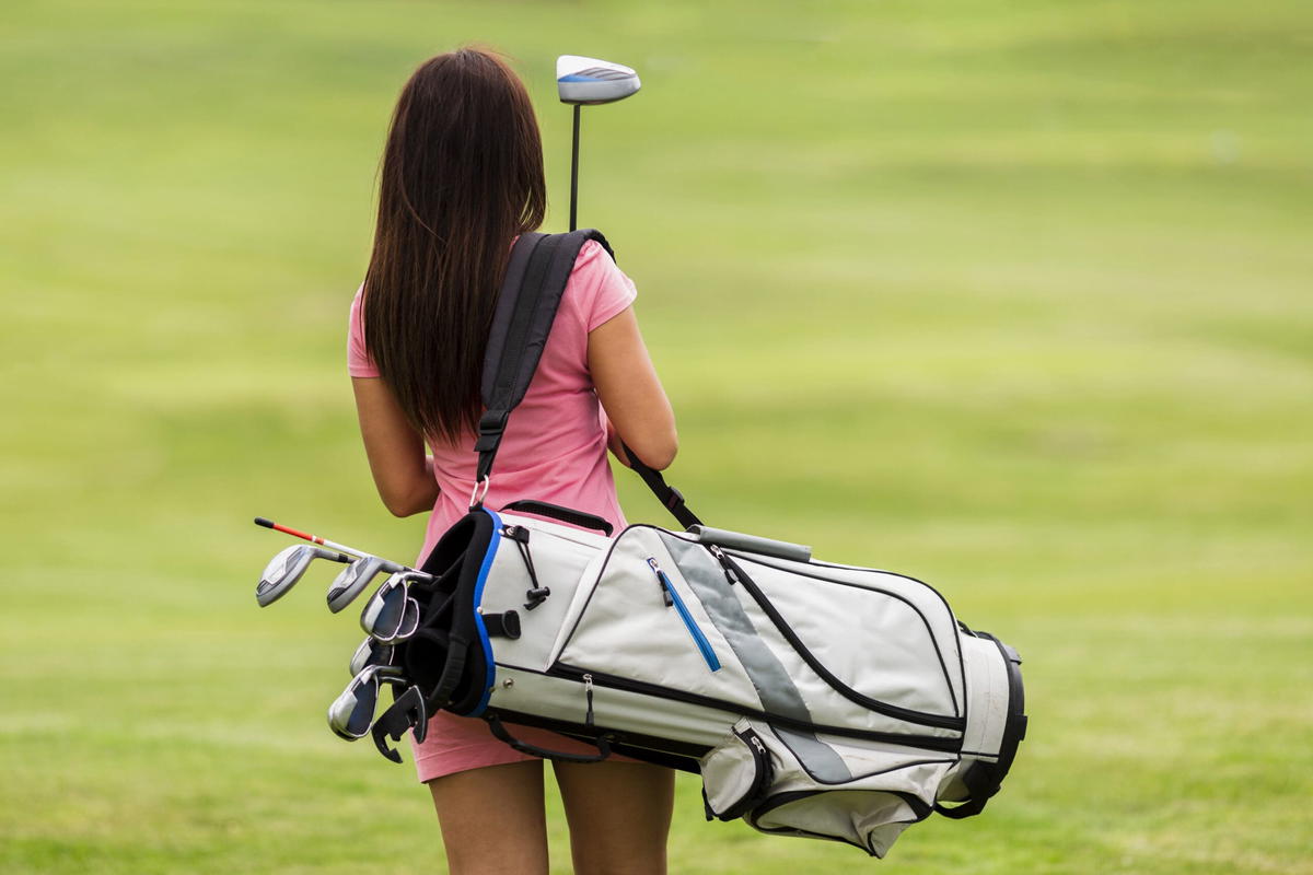 Woman carrying golf sticks