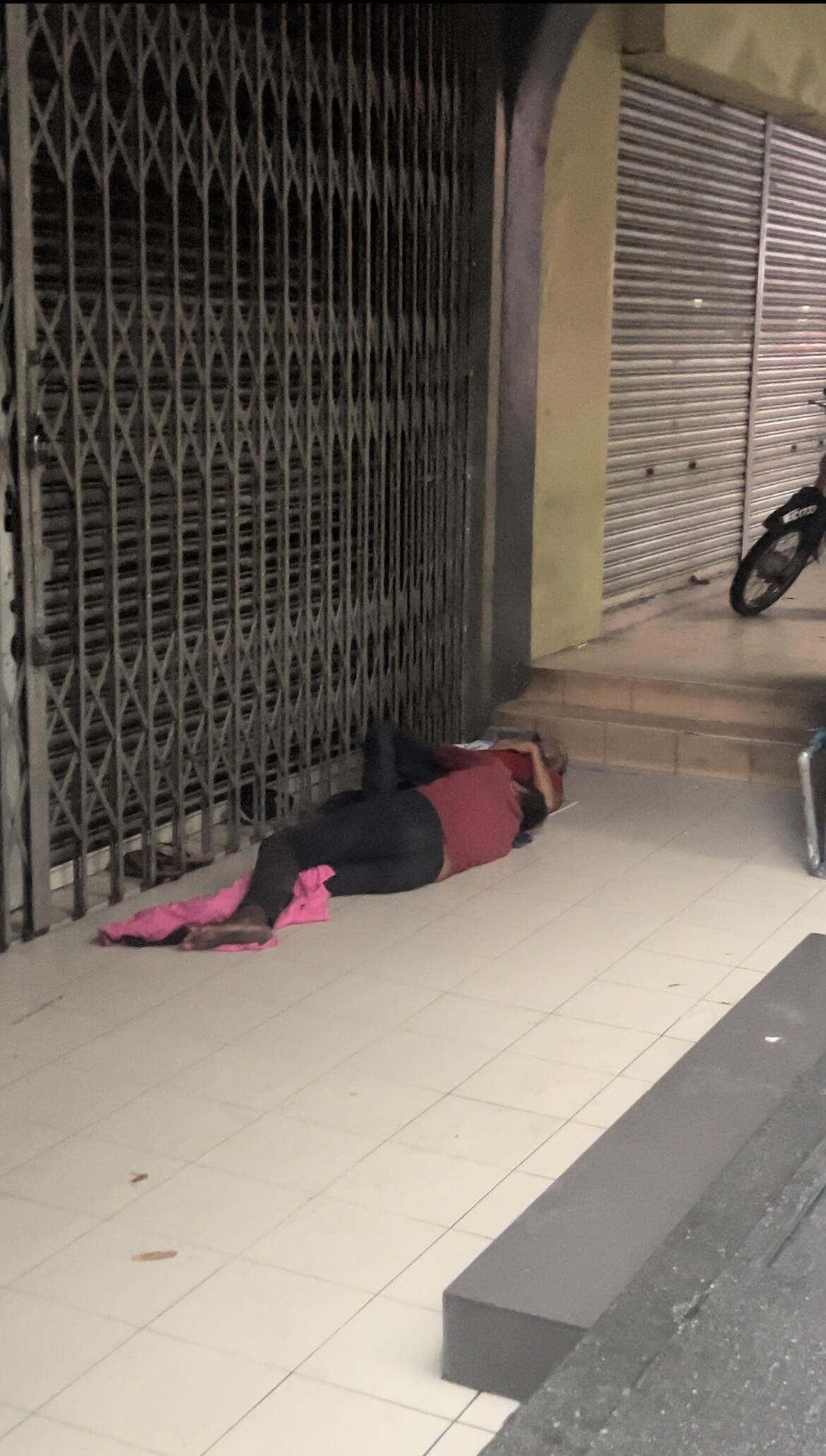 Beggar sleeping beside the street