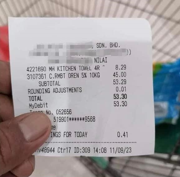 A msian man shows the receipt for the groceries he bought.