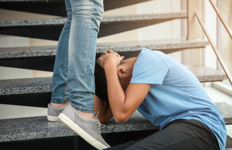 Boy covering his face while being attacked