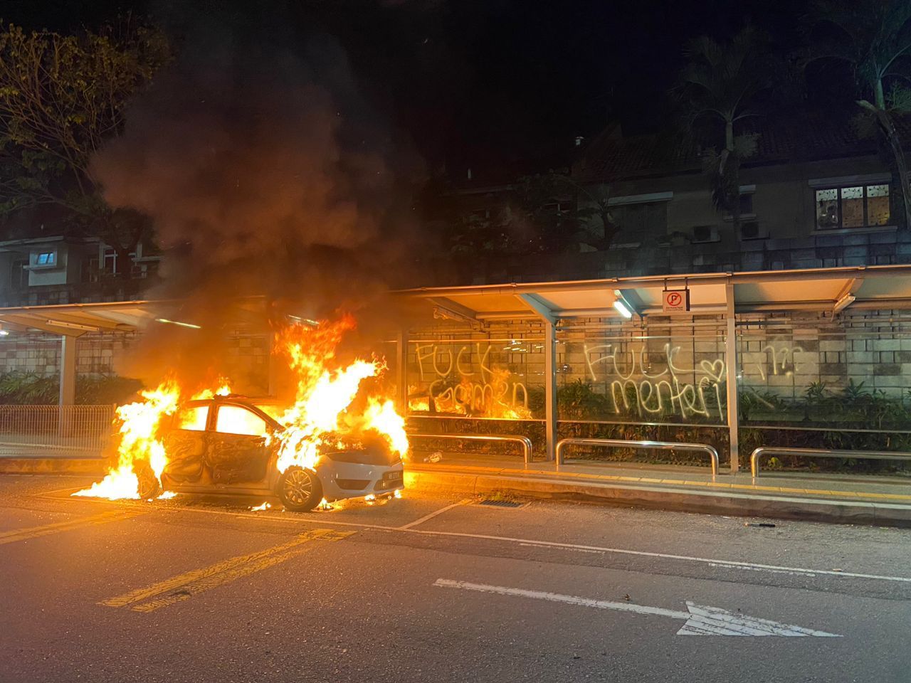 Burning police car near a bus stop