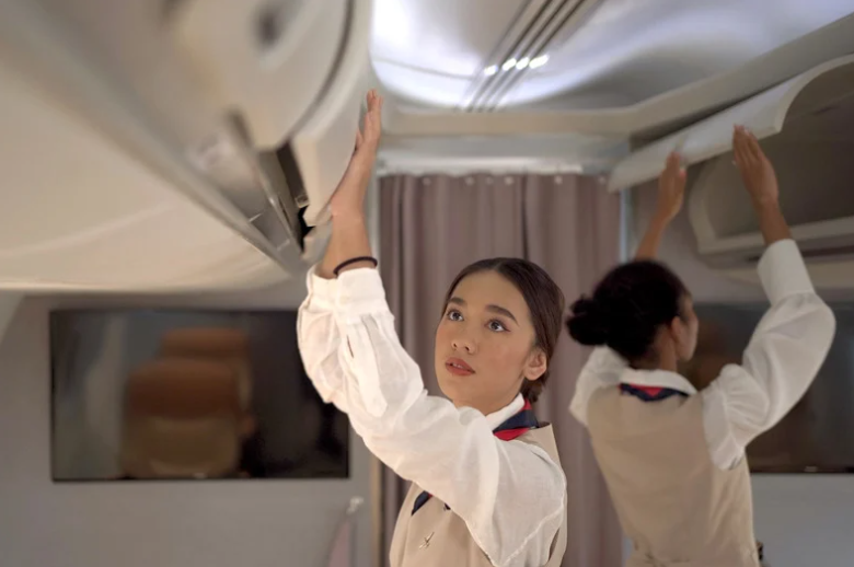 Cabin crew closing overhead compartment